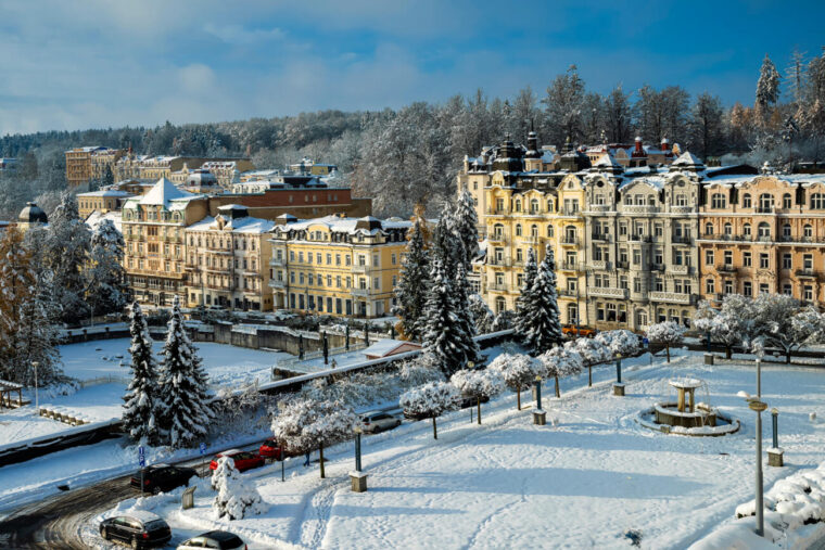 Friedensplatz mit Hotels in Marienbad, einem Kurort im Westböhmischen Bäderdreieck in Tschechien. Rechts das 4-Sterne-Hotel Palace Zvon im Renaissanchestil. Winterlandschaft mit Schnee.