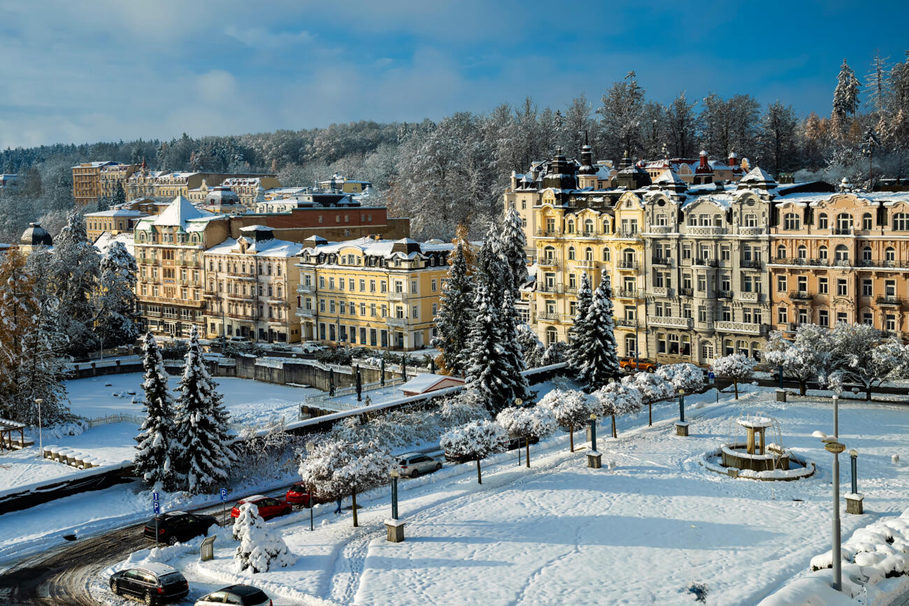 Friedensplatz mit Hotels in Marienbad, einem Kurort im Westböhmischen Bäderdreieck in Tschechien. Rechts das 4-Sterne-Hotel Palace Zvon im Renaissanchestil. Winterlandschaft mit Schnee.